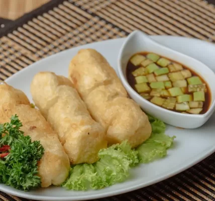 A golden-brown, crispy pempek served with tangy kuah cuko sauce.