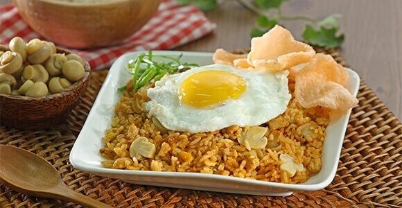 Nasi goreng jamur yang gurih dengan irisan jamur segar dan nasi berbumbu, siap disajikan hangat