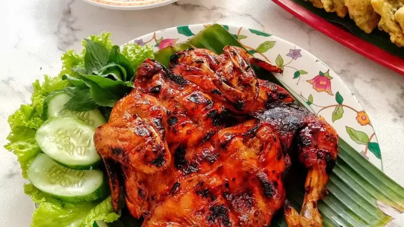 Ayam panggang madu berwarna kecokelatan mengilap, disajikan dengan taburan biji wijen dan irisan daun bawang