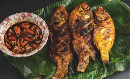 Hidangan ikan mas kecap dengan bumbu kecap manis dan rempah yang meresap sempurna, disajikan dengan nasi hangat