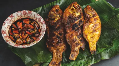 Hidangan ikan mas kecap dengan bumbu kecap manis dan rempah yang meresap sempurna, disajikan dengan nasi hangat