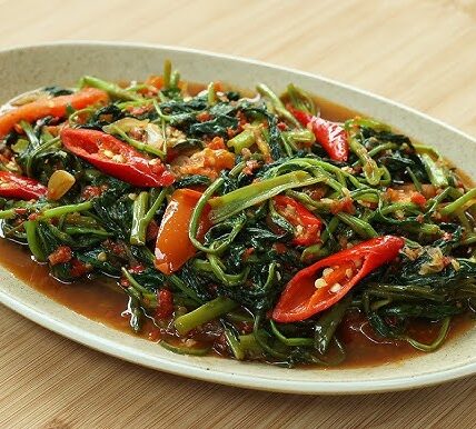 Sepiring tumis kangkung terasi dengan warna hijau segar dan aroma gurih